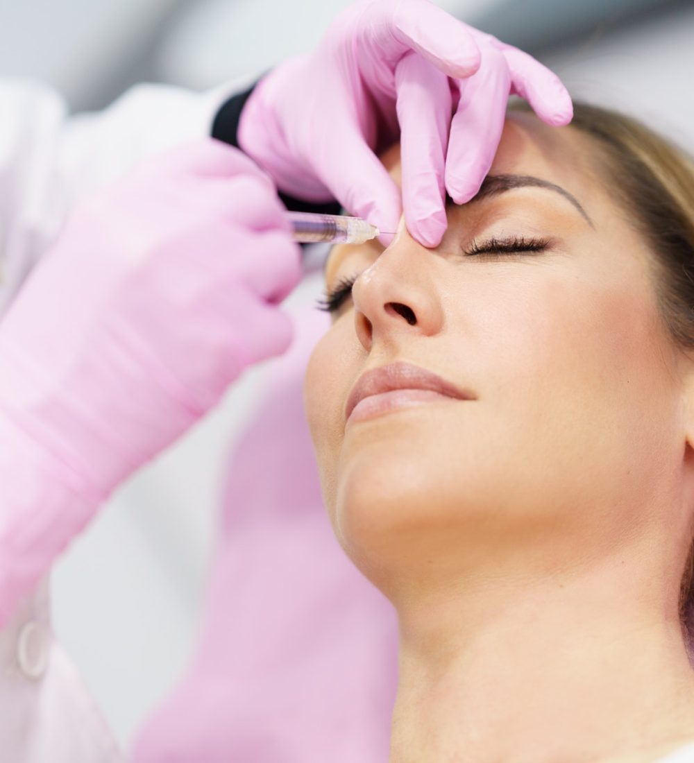 doctor-performing-rhinoplasty-by-injection-of-hyaluronic-acid-in-the-nose-of-his-patient-