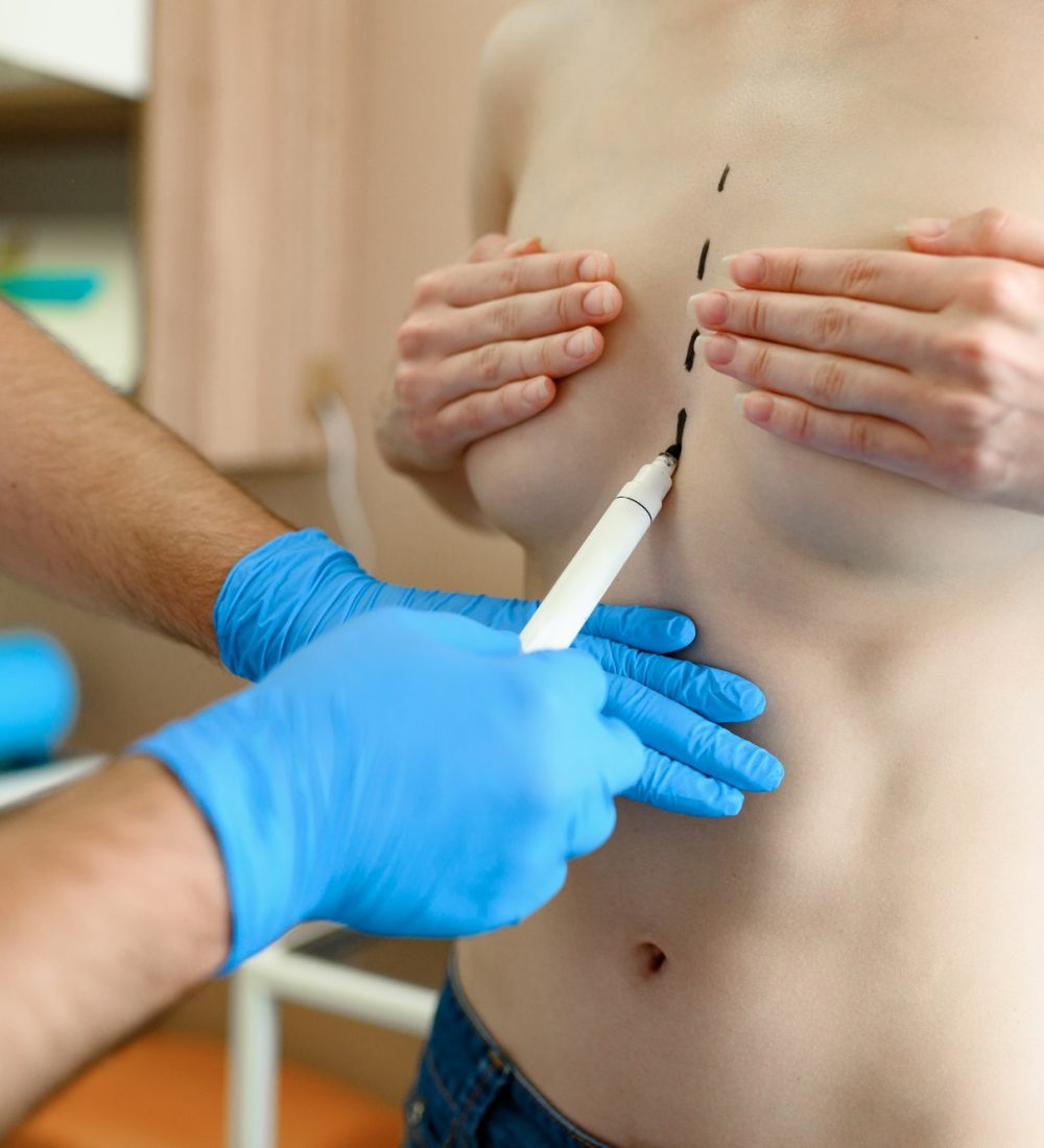 male-surgeon-prepares-woman-for-surgery-in-clinic